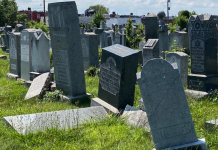 A row of gravestones are tilted and broken.