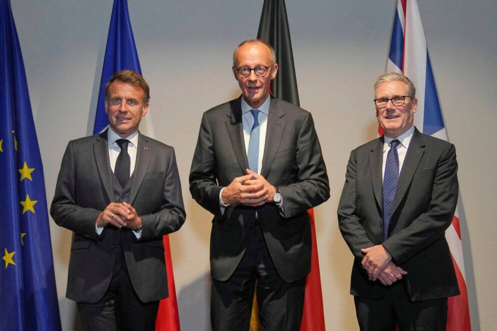 Three men standing in front of flags