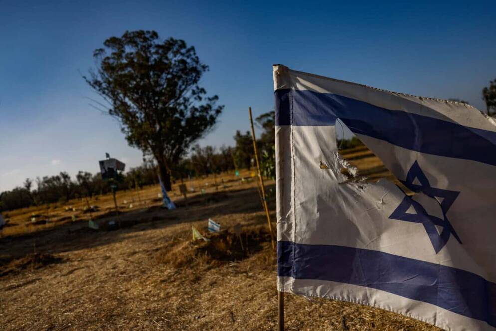 A blue and white Israeli flag and a tree.
