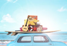 car driving along the beach with a pile of luggage on top