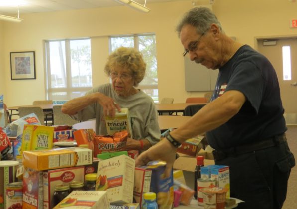 a man and woman sort through donated food