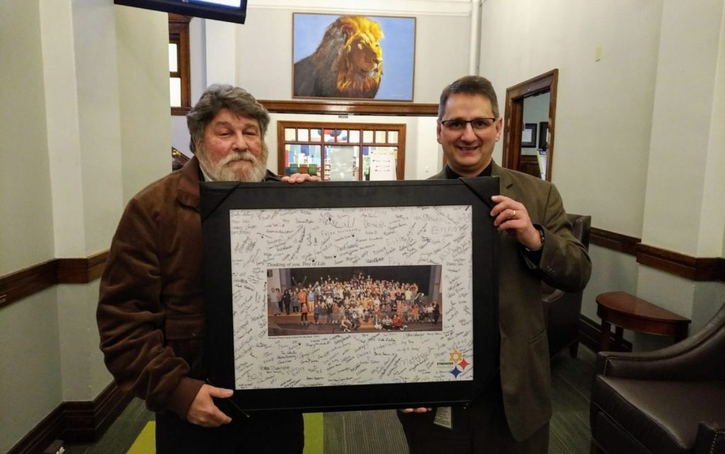 Isaac Levari and Steven Farmer hold a photo signed by Western Pennsylvania School for the Deaf students
