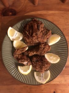 fried chicken on plate with lemon wedges