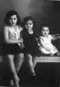 Black and white photo of two young girls and one baby girl sitting down