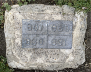 A grey plaque with faded numbers engraved in metal