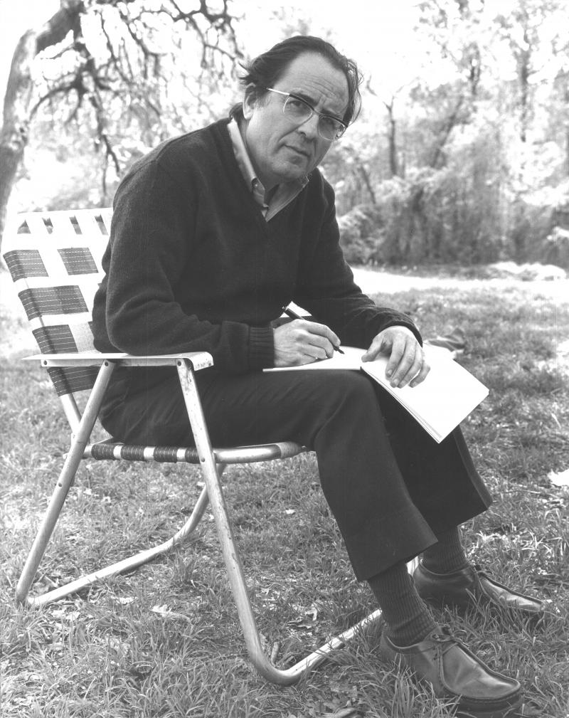 Philip Cohn, as a younger man, sits on a lawn chair with a sketchbook.