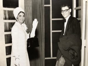 In a black and white photo, Maxine Rosen is waving at the camera and Elliot Rosen looks back and smiles.