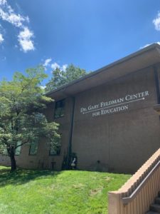 A visage of a brown brick building reads "Dr. Gary Feldman Center for Education"