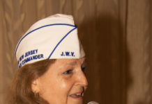 Selina Kanowitz is an older white woman with shoulder-length light brown hair. She is speaking in front of a microphone and podium.