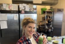 Rachel Klen is a white woman with blonde hair wearing a flannel. She is displaying a botton of green sauce and has her tattooed arms exposed.