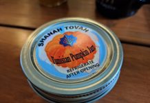 A jar lid of jam with a pumpkin on it reads, "SHANAH TOVAH. Tunisian Pumpkin Jam. Refrigerate after opening.
