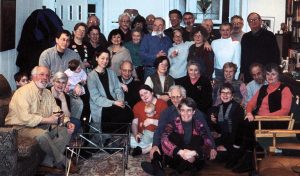 A group of people gather in someone's home for a photo.