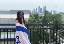 Avezu Fanta is a Black woman with long, black hair draped in an Israeli flag and standing on a balcony.