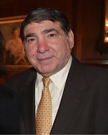 Irwin Gellman is a white man with short, brown hair wearing a suit and gold tie.