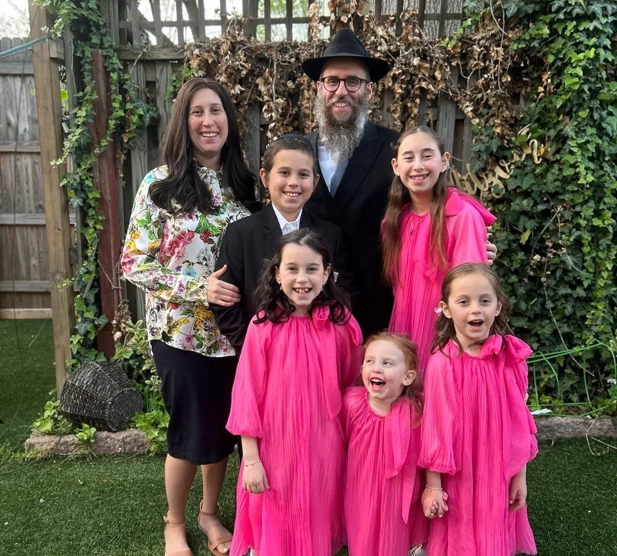 An Orthodox Jewish family smiles at the camera