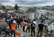 9 Killed by Iranian Missile Strike in Beit Shemesh A group of first responders at the site of a missile strike.