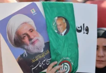 A woman holds pictures of Hezbollah leader Naim Qassem (left) and Lebanese Parliament Speaker Nabih Berri at Martyrs’ Square in central Beirut on April 30, 2026.