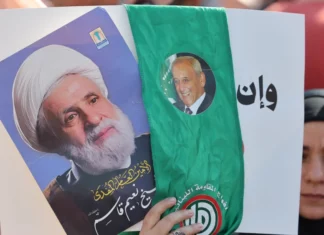A woman holds pictures of Hezbollah leader Naim Qassem (left) and Lebanese Parliament Speaker Nabih Berri at Martyrs’ Square in central Beirut on April 30, 2026.